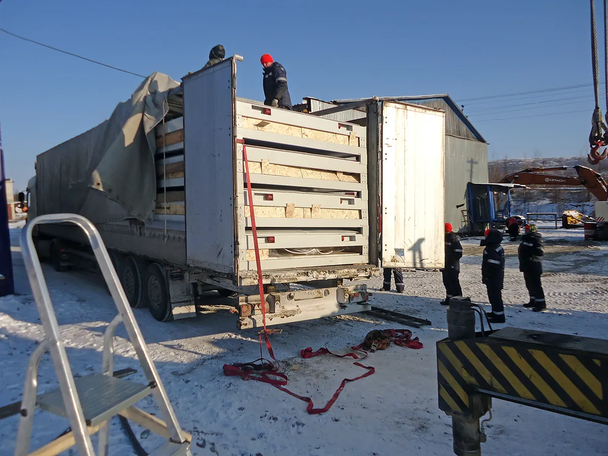 Разгрузка модуля с трала краном на площадке