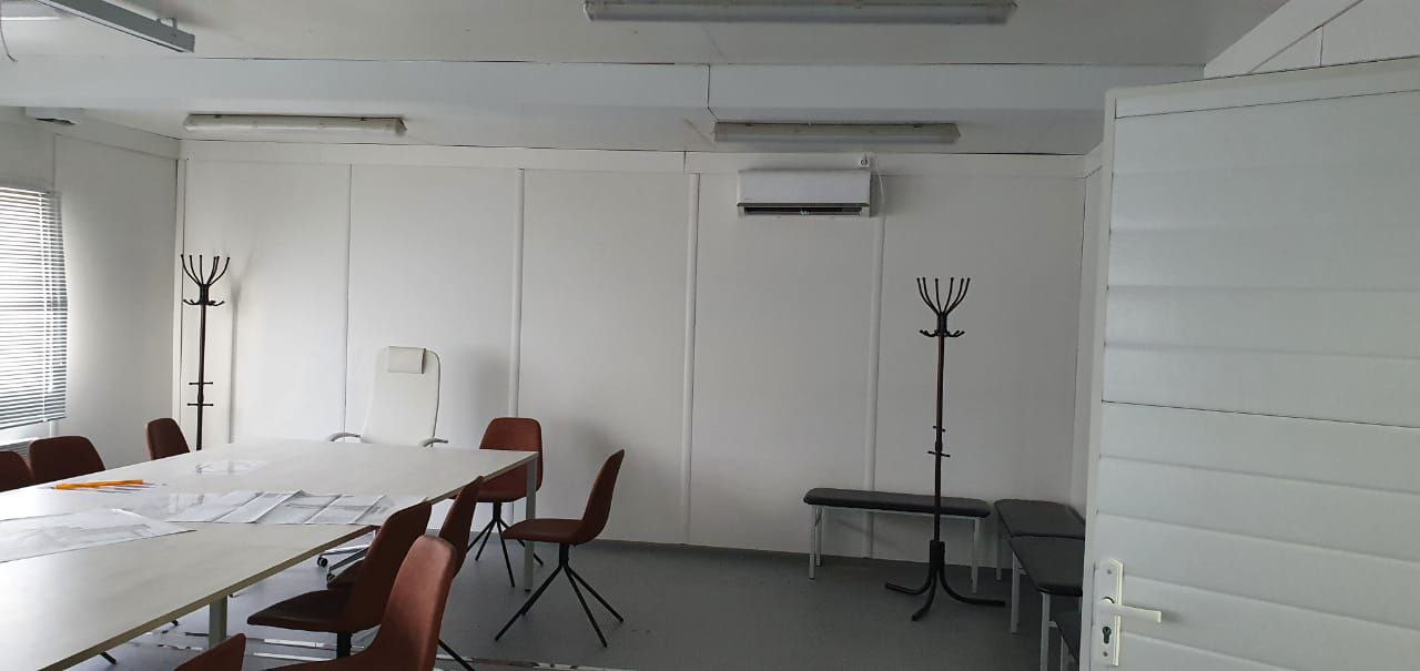 Office container interior — workstations with monitors and air conditioning