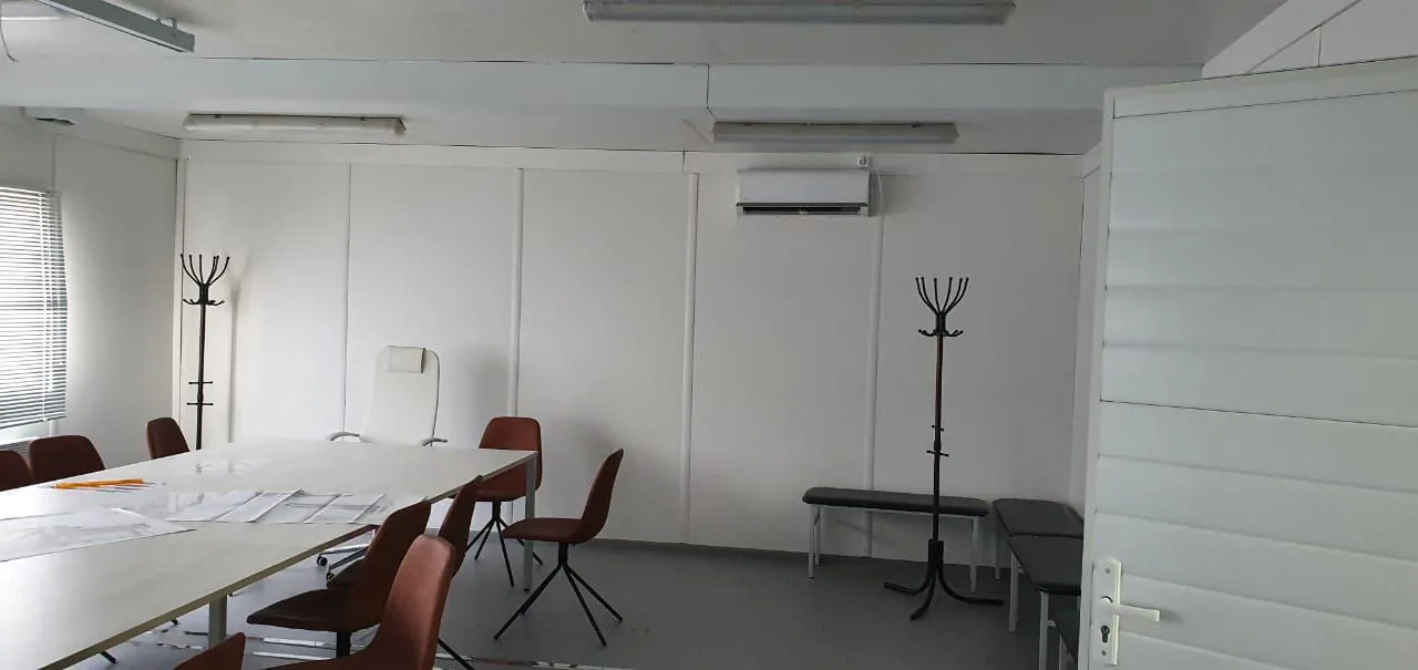 Office container interior — workstations with monitors and air conditioning