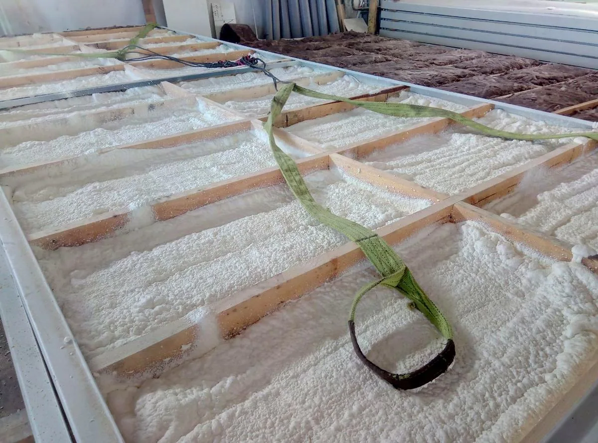 Укладка минеральной ваты в каркас модуля на производстве
